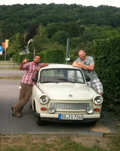 Avinash standing next to a white Trabi auto