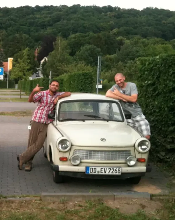 Avinash standing next to a white Trabi auto