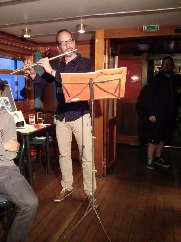 Tony Hyman behind a music stand playing the flute